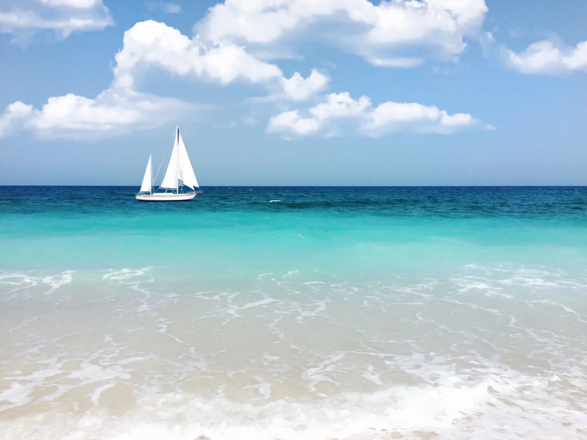 Voilier sur une mer turquoise près d’une plage